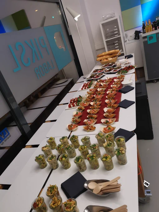 Auf dem Bild ist das Buffet zu sehen. Viele kleine Salate und Fingerfood stehen auf den Tischen.