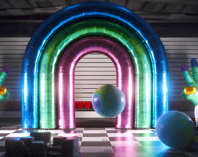 Large inflatable rainbow with a checkboard floor and inflatable toys 