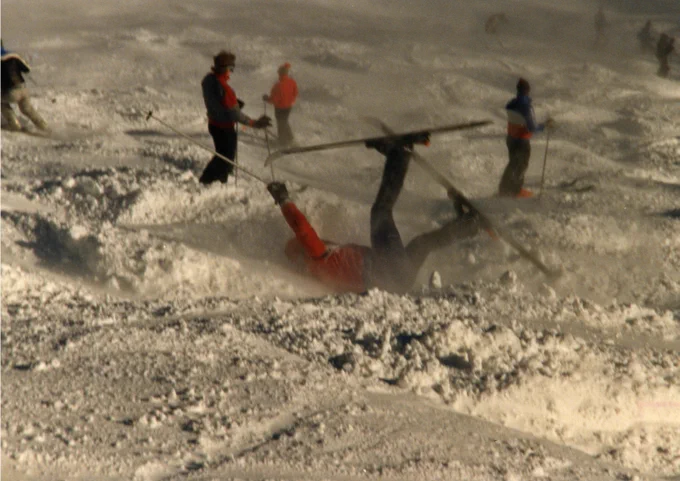 This image shows one of the members of the Appalachian State ski club, the Alpine Ski Team, falling into the snow while skiing on a slope in 1987. Other skiers can be seen in the background. The ski team at Appalachian State first appeared during the 1969-1970 school year.