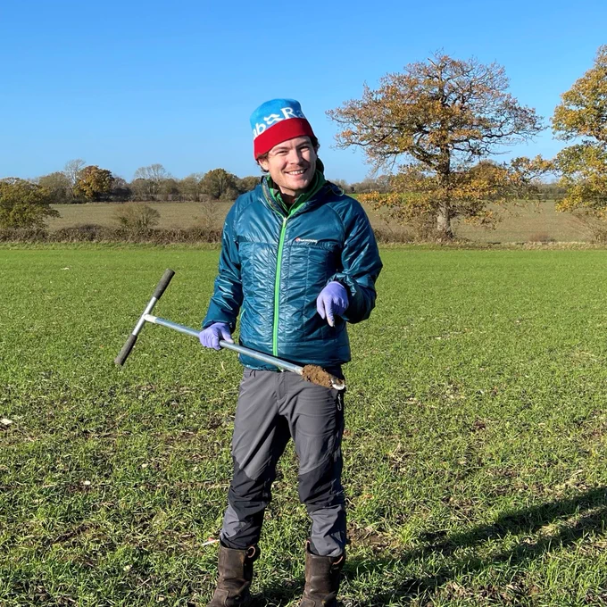 Researcher Tom Bott poses with an augur after taking soil samples from a sunny field in Norfolk. 