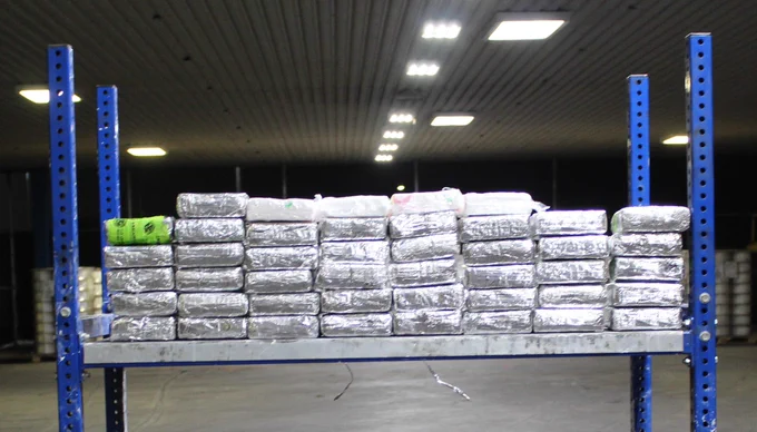 Silver packages stacked on a shelf, containing around 119 pounds of cocaine