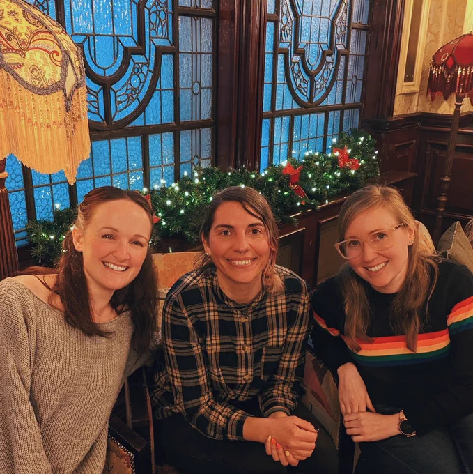 Emma, Carol and Anna are sitting at a table smiling at the camera