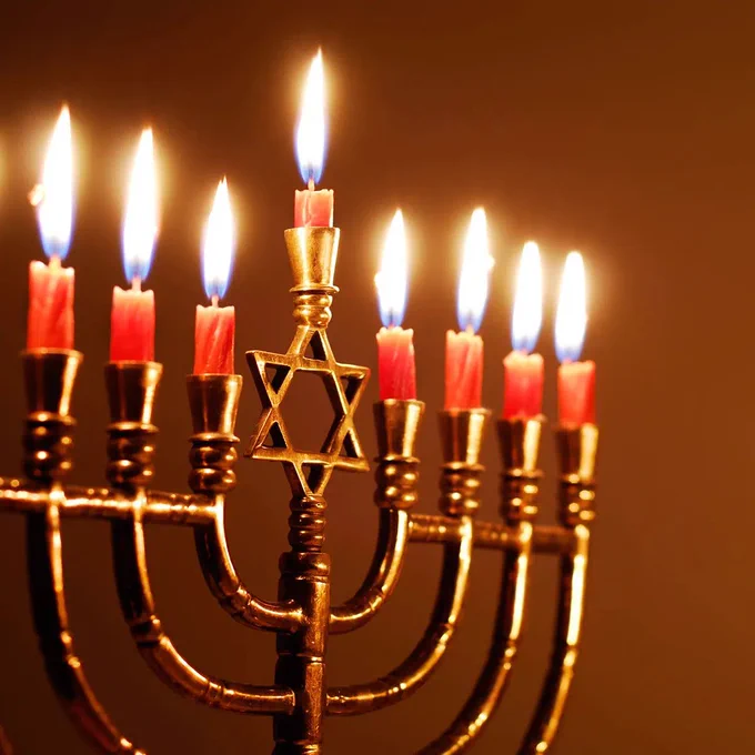 This is a photograph. There is a menorah with eight candles lit to celebrate Hanukkah. 
