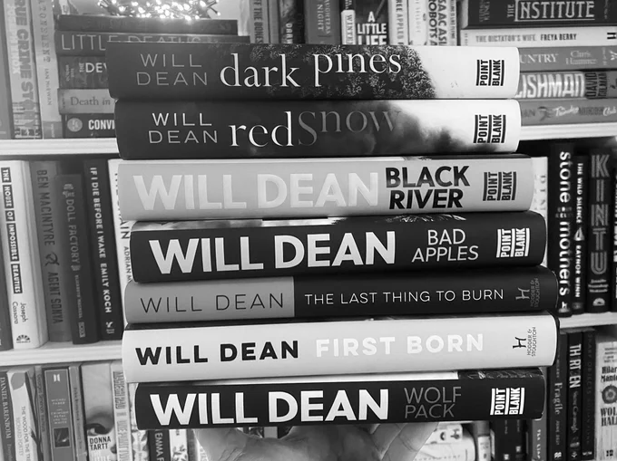A bookcase & a stack of novels (black & white)