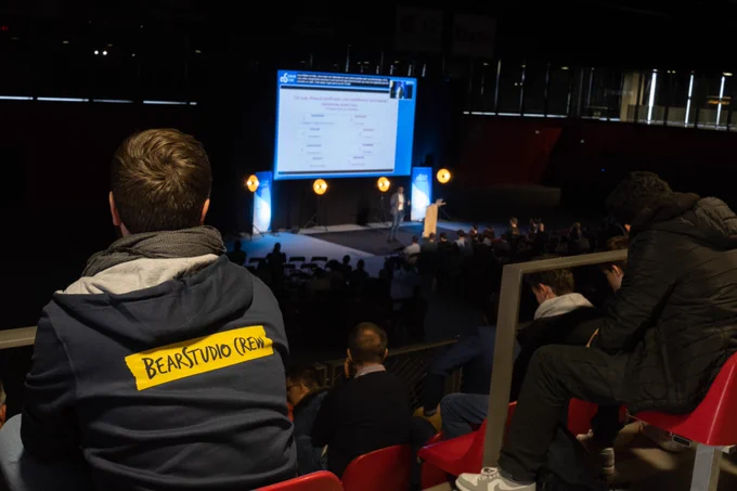 Ivan de dos, avec un hoodie BearStudio Crew, devant la conférence d'Abdelkrim Marchiani sur comment comprendre et communiquer avec les autres.