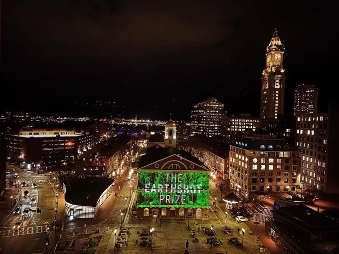 Image of Faneuil Hall and city ski line with green image of the earthshot prize