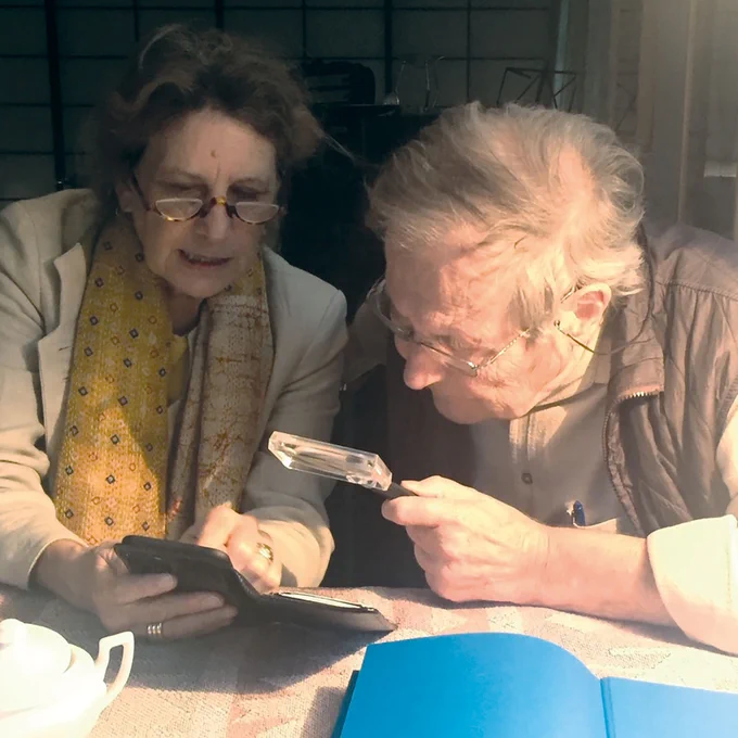 Dieter Oesterhelt looking at cover design drafts of his autobiography shown by Eva E. Wille in autumn 2021 · photo by Peter Goelitz