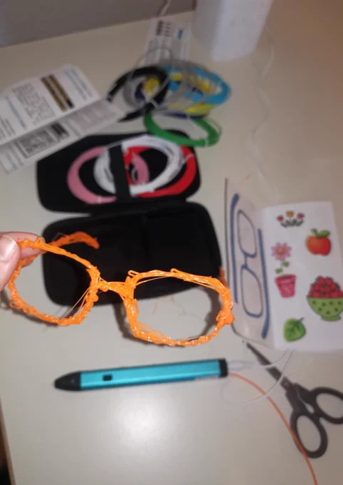 Zu sehen ist die gedruckte Brille und im Hintergrund liegen die Materalien auf einem Tisch.