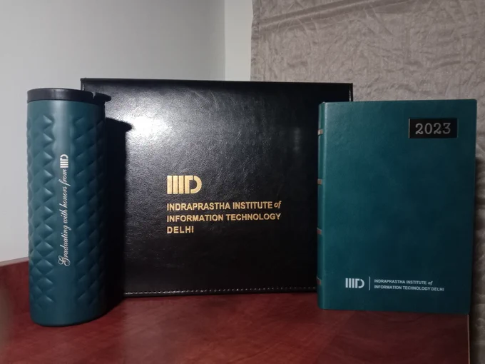 A water bottle that says "Graduating with honors from IIITD", the degree, and a diary!