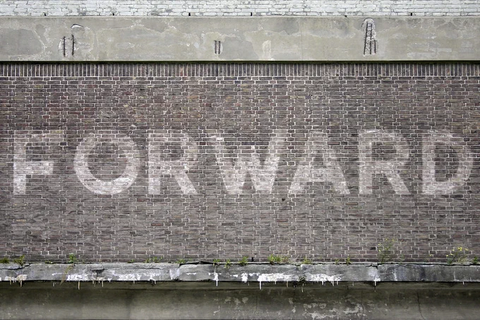 Detail of a faded sign reading “Forwarding”, painted in large white sans-serif caps on a brick wall at Wilhelminapier, Rotterdam, taken in October 2012