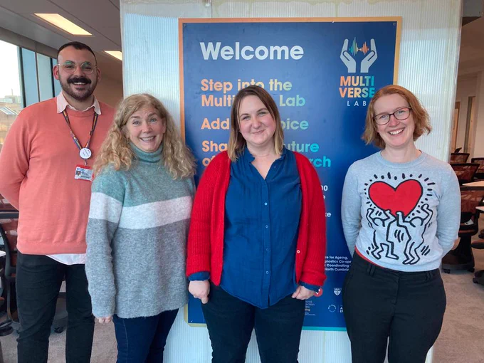 Charlie Wilkinson from Newcastle University, Felicity Shenton from National Institute for Health Research (NIHR), Kasia Kurowska from Newcastle University and Annie Rigby stand in front of a blue Multiverse Lab welcome sign.