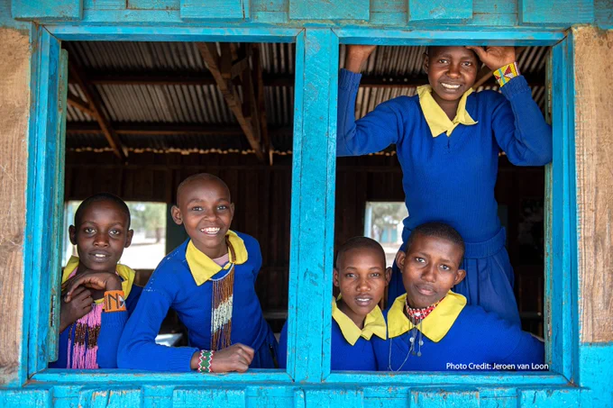 Female students posting in front of a school window!