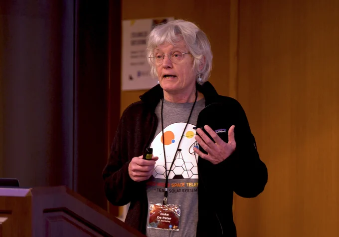 Photograph of Imke de Pater speaking to an audience. 