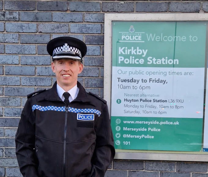 Photo of Dave Morgan in front of Kirkby Police Station sign 