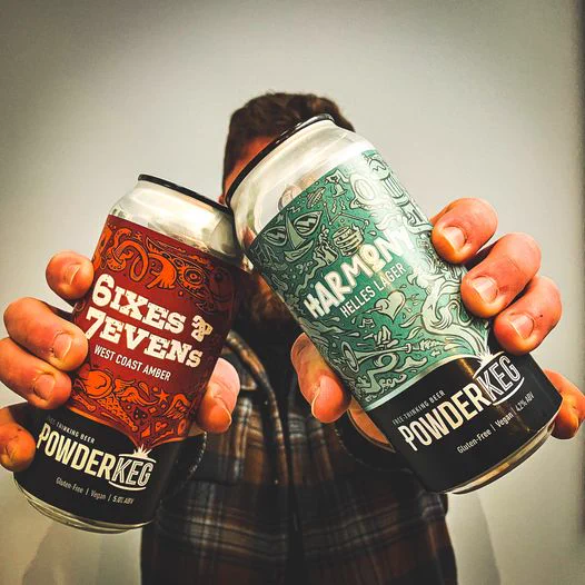 Hands holding cans of Harmony lager and sixes and Sevens west coast amber