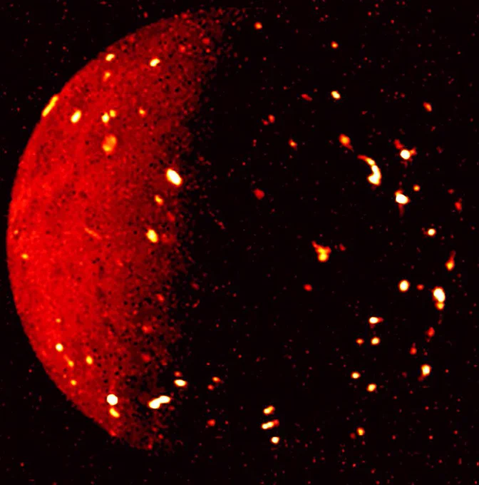 NASA’s Juno mission captured this infrared view of Jupiter’s volcanic moon Io on July 5, 2022, when the spacecraft was about 50,000 miles (80,000 kilometers) away. This infrared image shows a bright red glowing ball with speckles of orange, indicating a high temperature on the Jovian moon.
