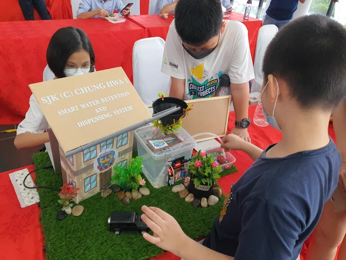 Smart water project with a model of a house and a plant pumping water controlled by a microbit. 