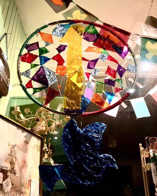 Image of a bespoke dove dream catcher in charity shop window.