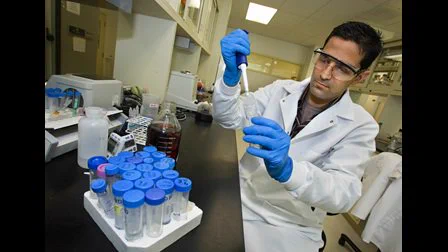 Photo of a male scientist working with test tubes while interning at a National Laboratory as part of the CCI Program