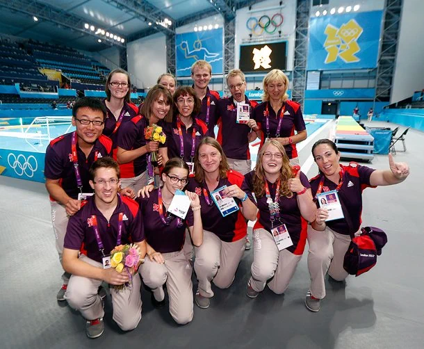 Volunteers at London 2012 posing for a photo inside the Aquatics Centre.