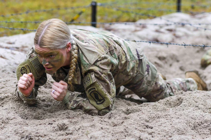 U.S. Army Capt. Valerie Nostrant, assigned to 1st Squadron, 91st Cavalry Regiment, 173rd Airborne Brigade, low crawls under barbed wire during the obstacle course portion of a spur ride at the 7th Army Training Command's Grafenwoehr Training Area, Germany, Dec. 14, 2021. The purpose of this spur ride is to integrate new paratroopers into the Airborne Cavalry and build esprit de corps within the squadron, focused on Cavalry heritage. (U.S. Army photo by Markus Rauchenberger)