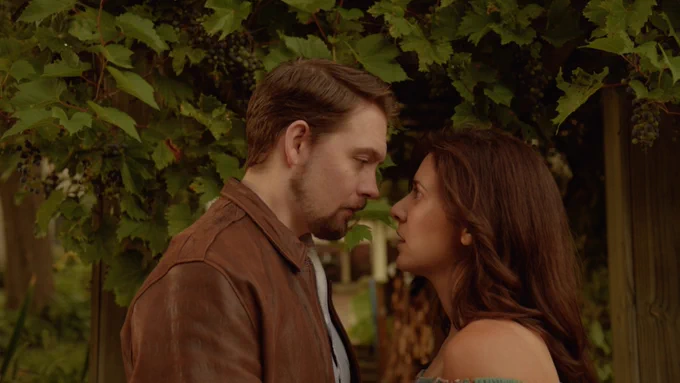 Ana and Fred stand outside, their faces close together