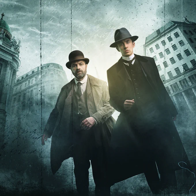 Oskar Rheinhardt (Juergen Maurer) and Max Liebermann (Matthew Beard) stride forward with purpose, surrounded by buildings
