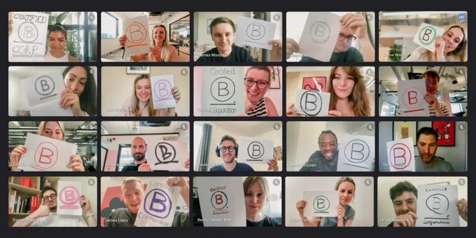 An image of a Google Meets call of 20 of our team, each joining the call from their work-from-home set up, smiling and holding up hand-drawn B Corp logos.