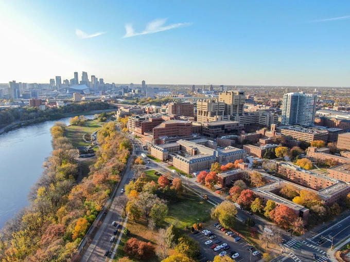 University of Minnesota-Twin Cities campus with the city skyline of Minneapolis in the distance across the Mississippi River.