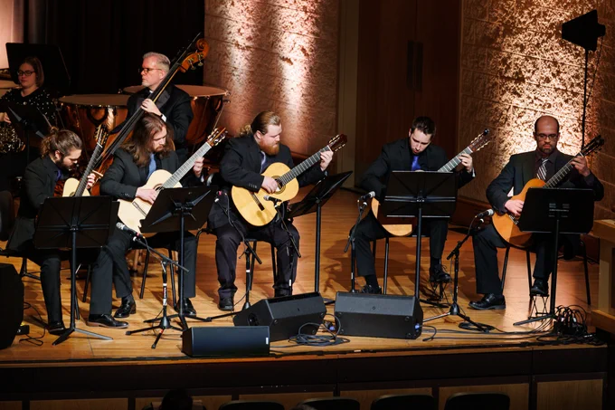 Five guitarists perform "Go, Tell it on the Mountain" on stage during Purdue Fort Wayne's Home for the Holidays concert.