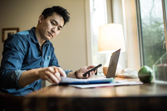 A man on his computer and phone doing work