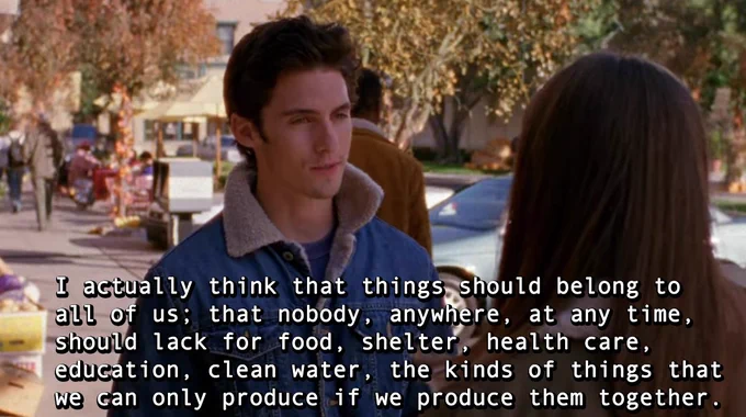 A still from the show Gilmore Girls of the character Jess facing towards the camera and looking at Rory Gilmore, the back of whose head is towards the camera. The caption is the Ruth Wilson Gilmore quote: "I actually think that things should belong to all of us: that nobody, anywhere, at any time, should lack for food, shelter, health care, education, clean water, the kinds of things that we can only produce if we produce them together."