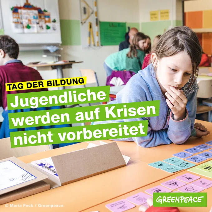 Das Foto zeigt das Klassenzimmer einer 5. Klasse mit Fokus auf eine Schülerin, die im Rahmen eines Schools for Earth Workshops das Klima Kit von Greenpeace spielt. 