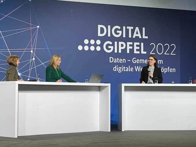 Drei Frauen am Podium, dahinter die Aufschrift "Digitalgipfel 2022"