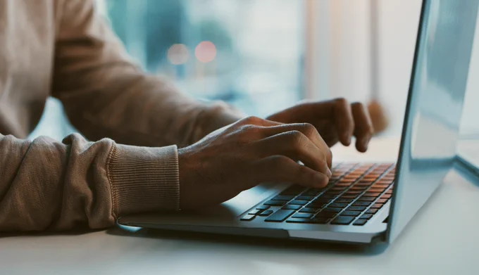 Close-up of someone working on a laptop  