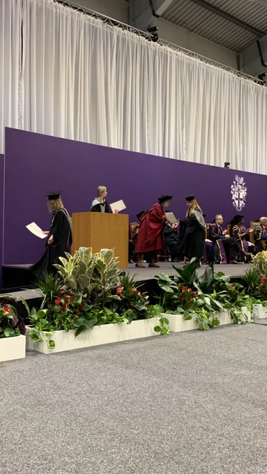 A graduate shakes hands and receives their certificate.