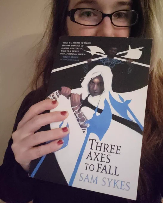 Daniece holding up her copy of Sam Syke's book, "Three Axes to Fall"