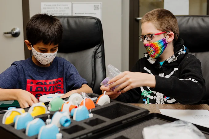 [Image description: Two children explore CodeJumper™ at the CNIB Regina Office.]