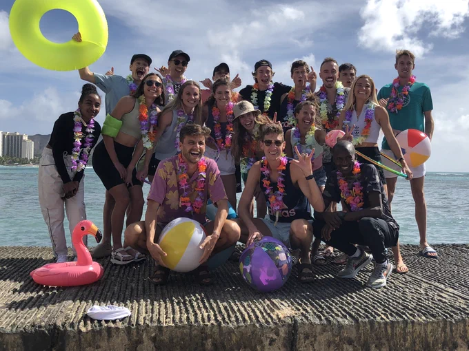Group shot of the elite athletes participating in the Kalakaua Merrie Mile, posing on Waikiki Beach in Honolulu.