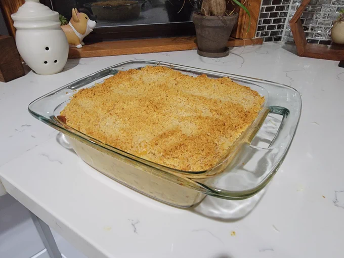 Casserole dish filled with baked macaroni and cheese covered with toasted breadcrumbs 