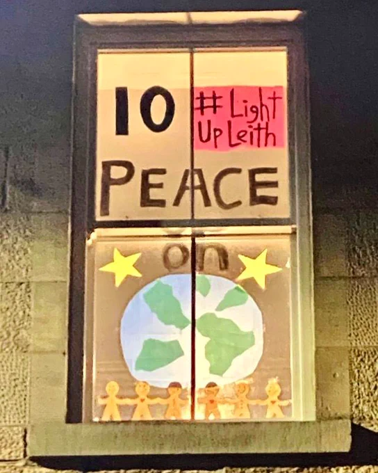 Festive window display marking the 10th day of advent with “peace on earth” written in window.