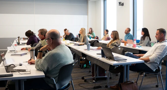 A class of working professionals listening to a lecture