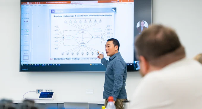 An instructor teaching a class of working professionals