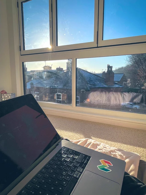 My MacBook in the foreground and a floor to ceiling window in the background showing frosty rooftops.