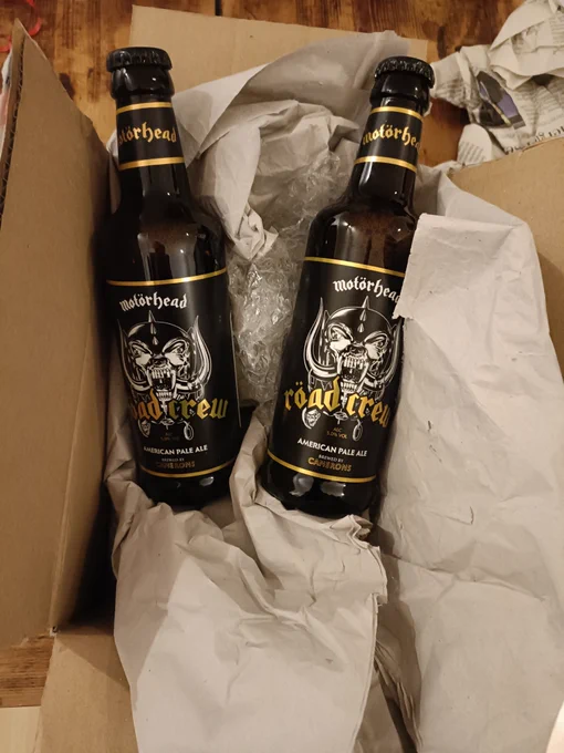 Two bottles of Motorhead road crew American pale ale lying on the box and wrapping paper they were sent in