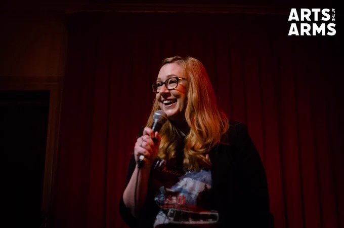 Vic Bingham doing stand-up comedy in a festive jumper.