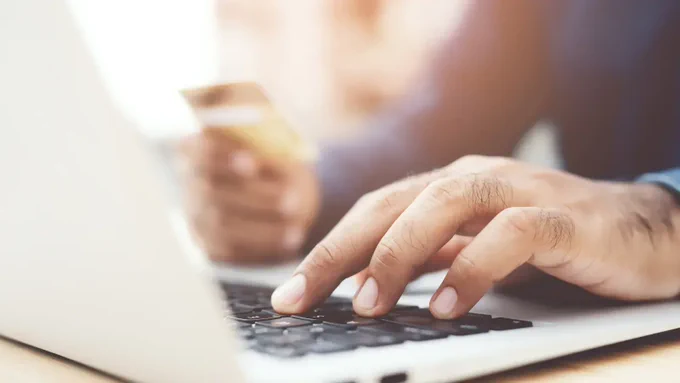 A close up of a hand typing on a laptop computer