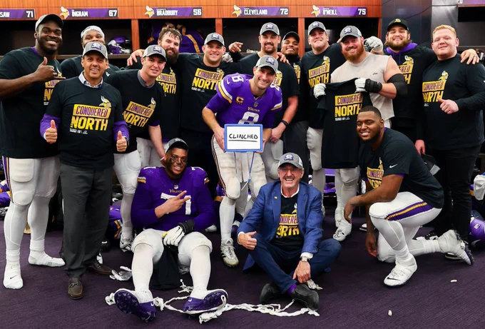 Members of the Vikings team pose with Owners Mark and Zygi Wilf in the locker room following tonight's NFC North clinching win. 