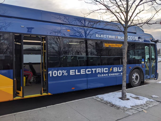Blue electric single decker bus with text on the side reading "100% electric bus"