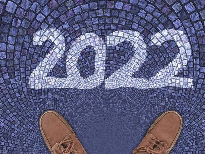 Brown shoes standing on blue-grey tiles with 2022 in white on the tiles.